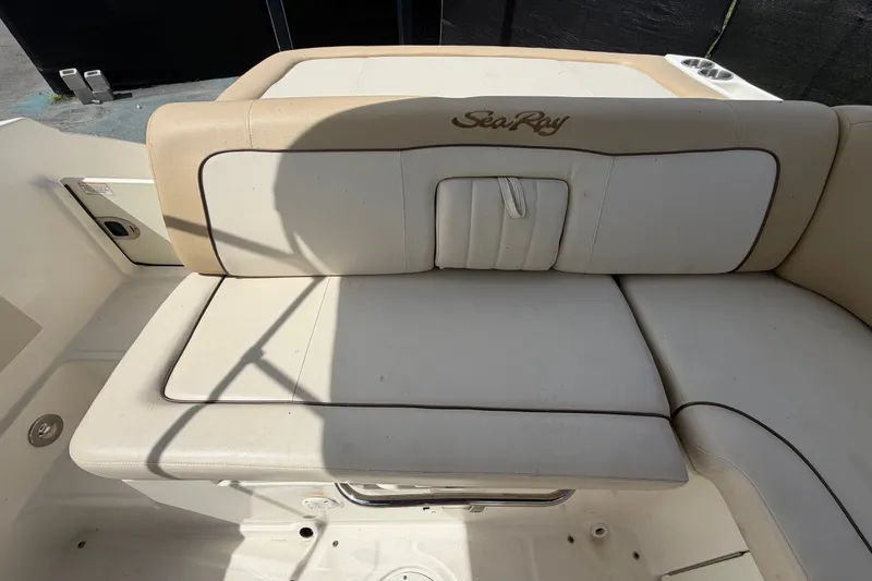 Slide: The Image of 2014 Sea Ray 240 Sundeck boat seating area with beige upholstery and logo. - 77