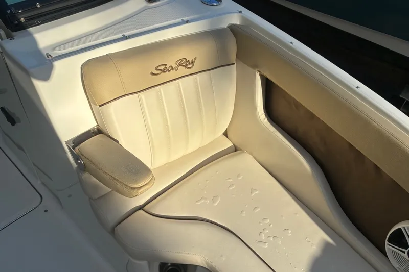Slide: The Image of 2014 Sea Ray 240 Sundeck boat seat with beige upholstery and embroidered logo. - 23