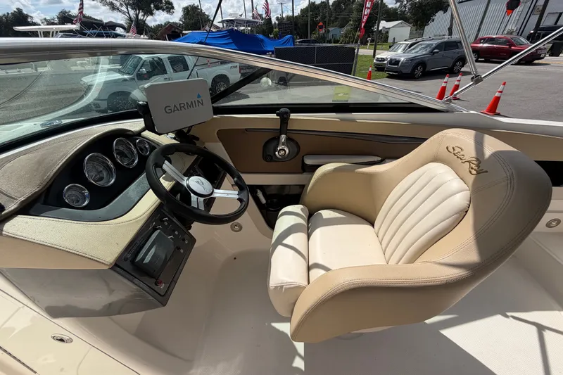 Slide: The Image of 2014 Sea Ray 240 Sundeck cockpit with Garmin navigation and plush captain's chair. - 30