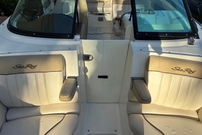 Slide: The Image of 2014 Sea Ray 240 Sundeck interior with beige seating and Sea Ray logo. - 21