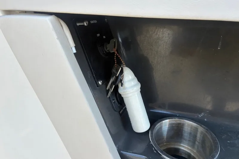 Slide: The Image of Ignition keys in a 2014 Sea Ray 240 Sundeck boat, next to a cup holder. - 50