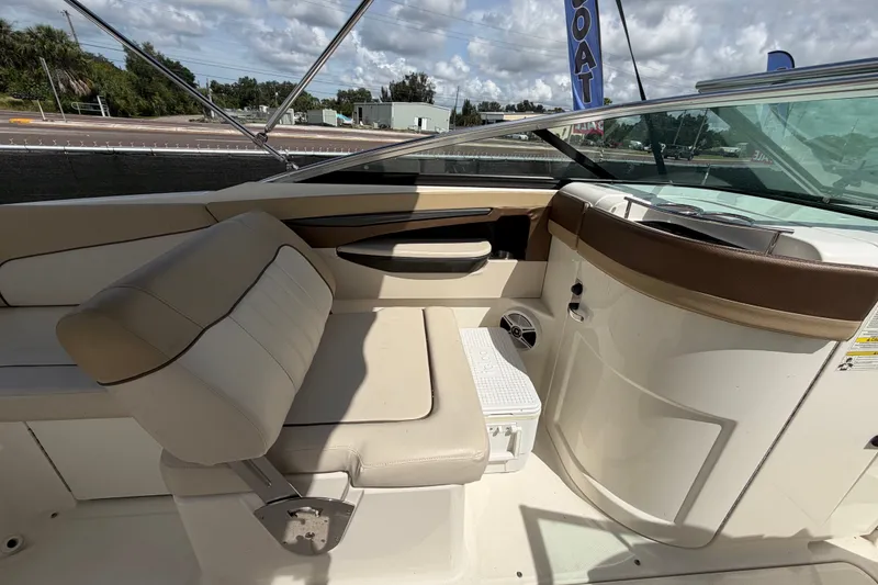 Slide: The Image of 2014 Sea Ray 240 Sundeck interior with beige seating and sleek dashboard design. - 24