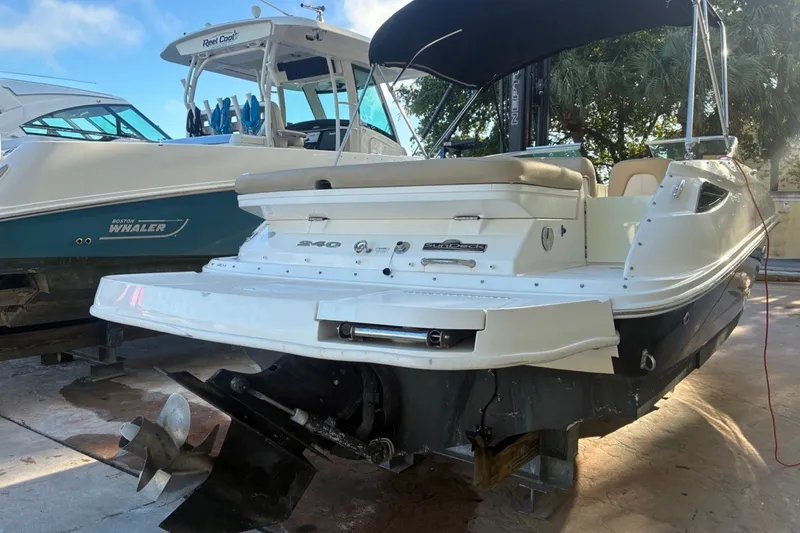 Slide: The Image of 2014 Sea Ray 240 Sundeck boat on dry dock, showcasing rear view and propeller. - 7