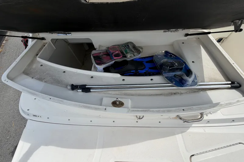 Slide: The Image of Open storage compartment on 2014 Sea Ray 240 Sundeck with snorkeling gear and accessories. - 14