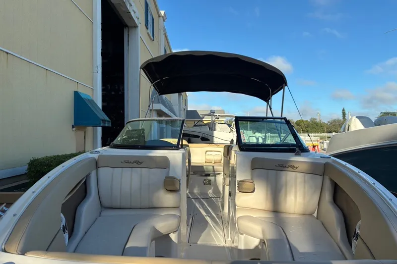 Slide: The Image of 2014 Sea Ray 240 Sundeck boat with spacious seating and canopy, docked outdoors. - 13