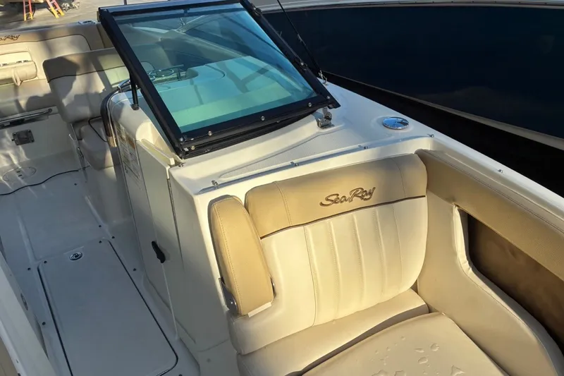 Slide: The Image of 2014 Sea Ray 240 Sundeck interior with beige seating and windshield. - 22