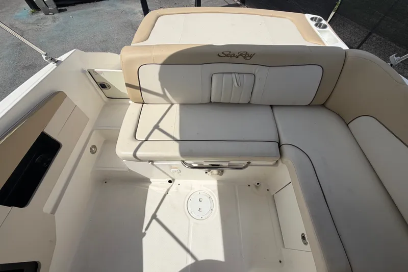 Slide: The Image of 2014 Sea Ray 240 Sundeck interior seating area with beige upholstery and cup holders. - 70