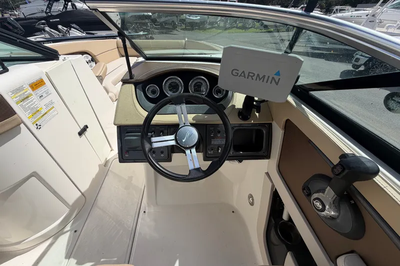 Slide: The Image of 2014 Sea Ray 240 Sundeck cockpit with Garmin navigation system and steering wheel. - 32