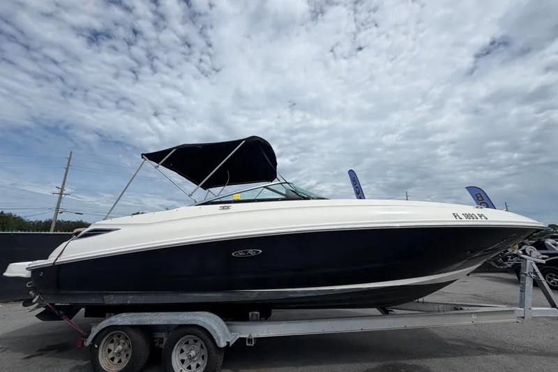 Slide: The Image of 2014 Sea Ray 240 Sundeck boat on trailer under cloudy sky. - 1