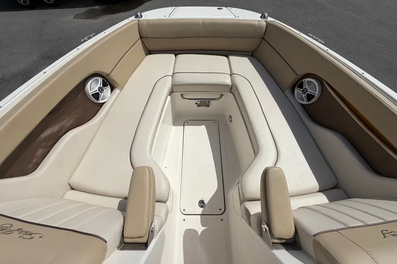 Slide: The Image of 2014 Sea Ray 240 Sundeck interior with beige seating and built-in speakers. - 49