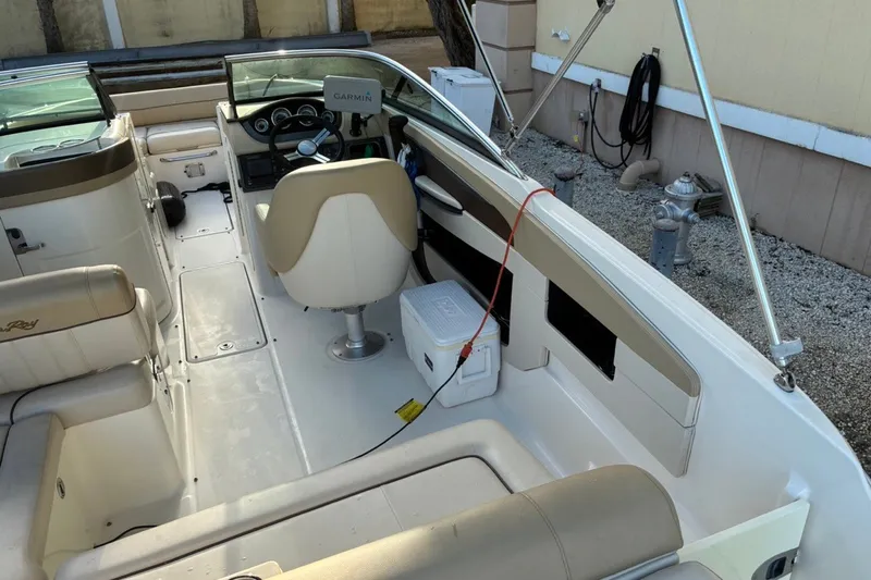 Slide: The Image of 2014 Sea Ray 240 Sundeck interior with beige seating and Garmin navigation system. - 29