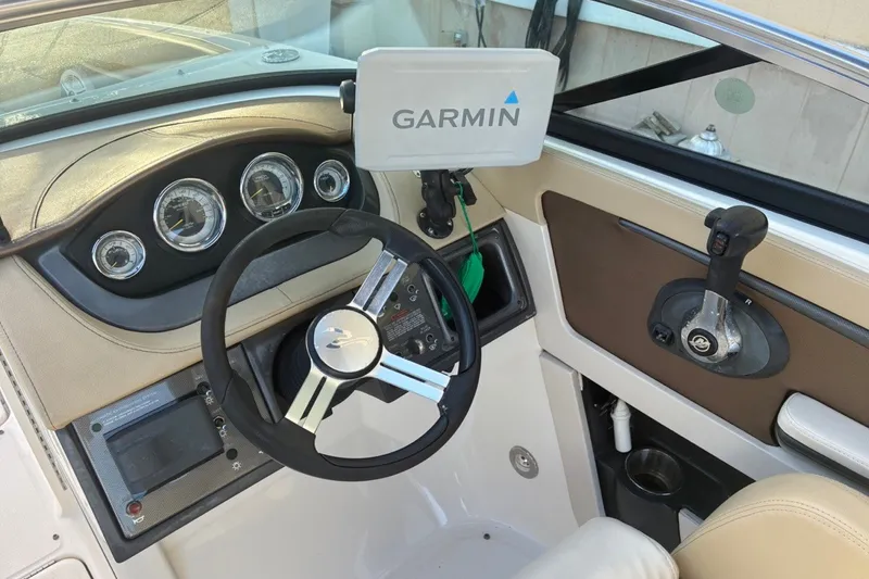 Slide: The Image of 2014 Sea Ray 240 Sundeck helm with Garmin navigation and sleek steering controls. - 41