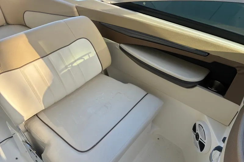 Slide: The Image of 2014 Sea Ray 240 Sundeck interior with beige seating and built-in speaker. - 35