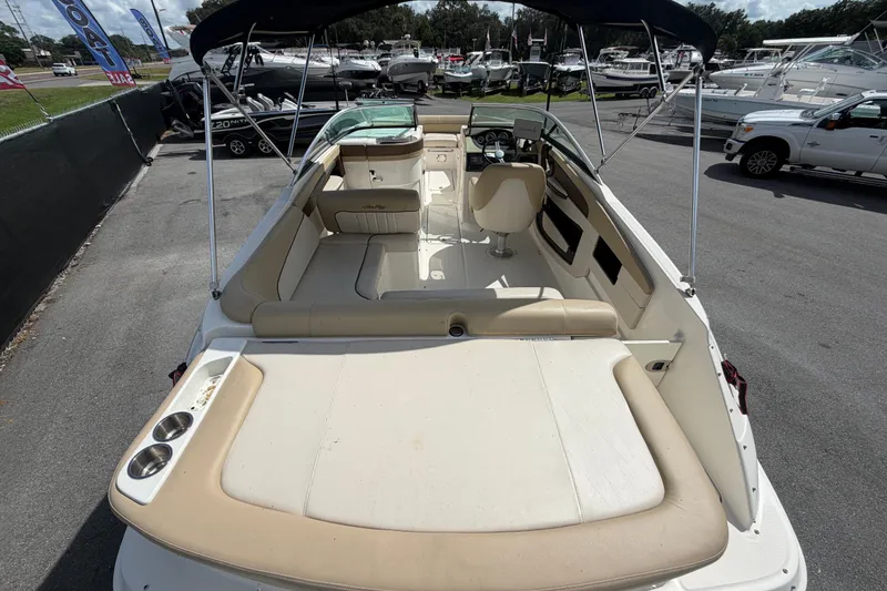 Slide: The Image of 2014 Sea Ray 240 Sundeck boat with spacious seating and canopy, parked at a marina. - 12