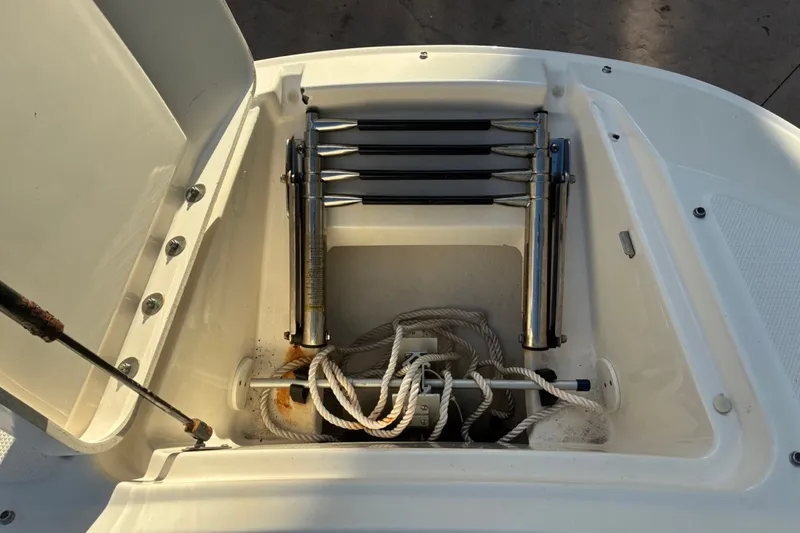 Slide: The Image of Open storage compartment on 2014 Sea Ray 240 Sundeck boat with ladder and ropes. - 18