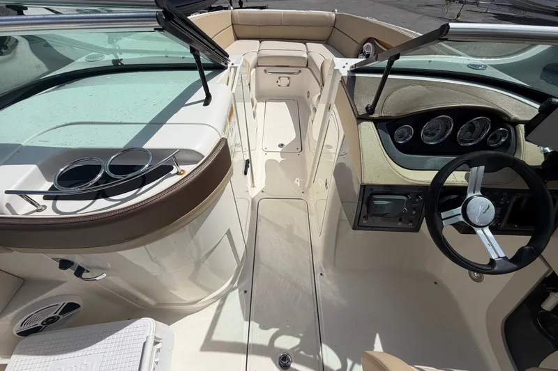 Slide: The Image of 2014 Sea Ray 240 Sundeck interior with steering wheel and seating area. - 40