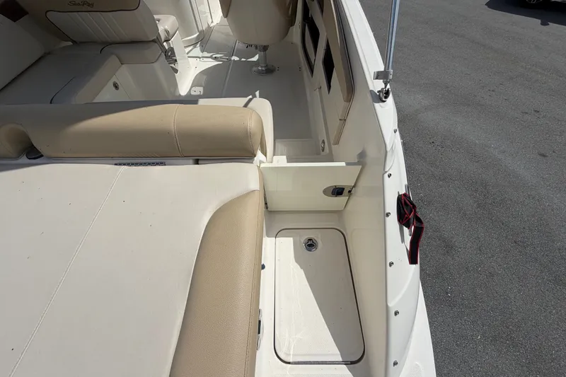 Slide: The Image of 2014 Sea Ray 240 Sundeck interior with beige seating and storage compartments. - 16