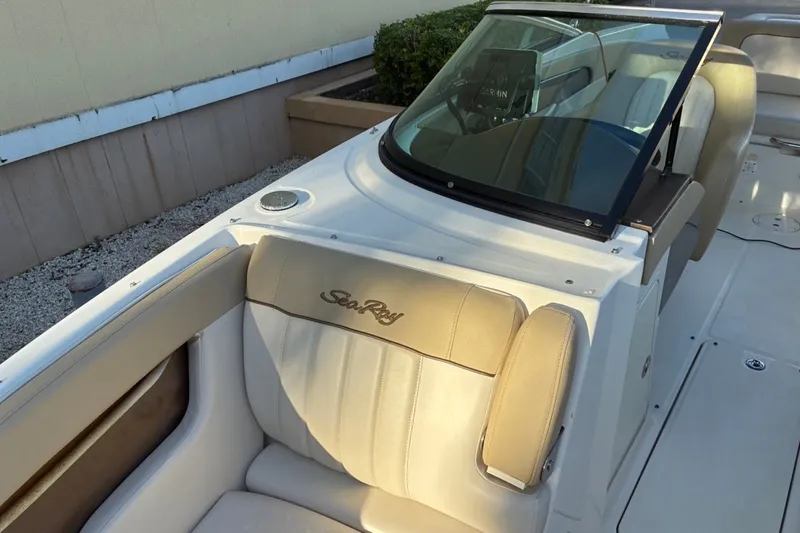 Slide: The Image of 2014 Sea Ray 240 Sundeck boat interior with beige seating and windshield. - 24