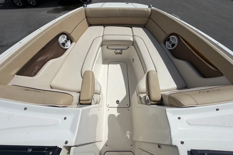 Slide: The Image of 2014 Sea Ray 240 Sundeck boat interior with beige seating and built-in speakers. - 48