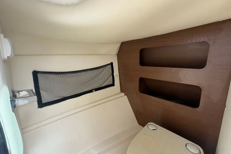 Slide: The Image of Interior cabin of 2014 Sea Ray 240 Sundeck with storage compartments and netting. - 28