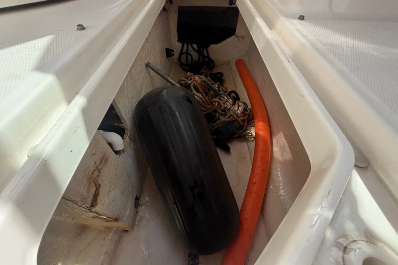 Slide: The Image of Storage compartment of 2014 Sea Ray 240 Sundeck with fender, rope, and orange hose. - 42