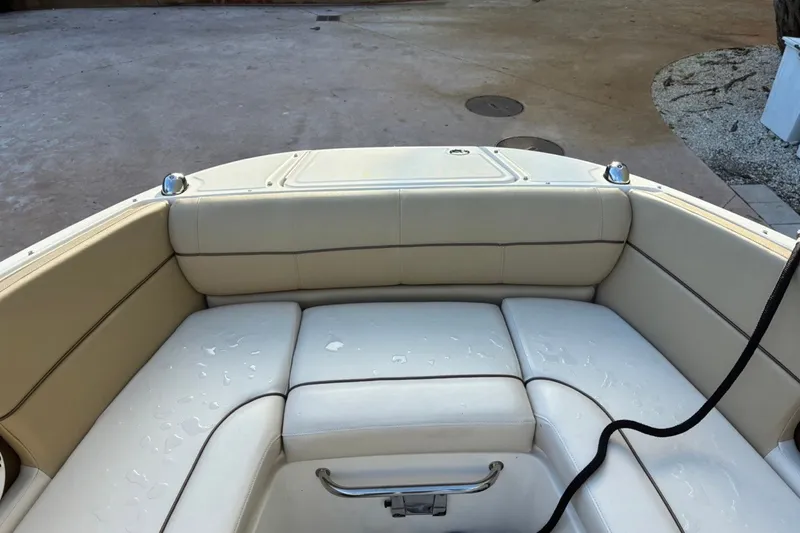 Slide: The Image of 2014 Sea Ray 240 Sundeck boat interior with beige seating and stainless steel handle. - 17