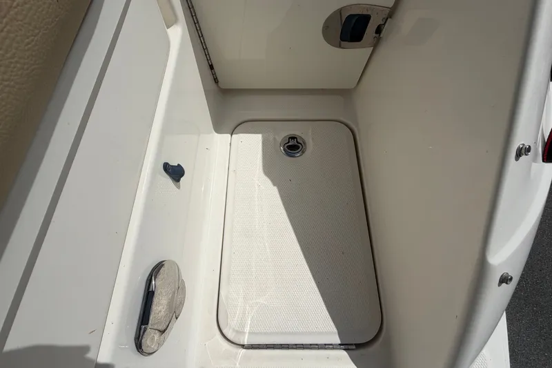 Slide: The Image of 2014 Sea Ray 240 Sundeck storage compartment with latch and textured surface. - 17