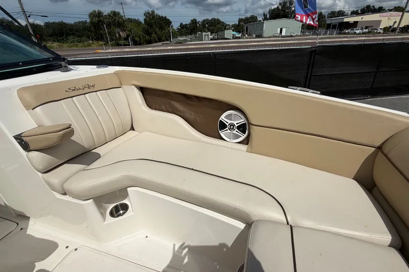 Slide: The Image of 2014 Sea Ray 240 Sundeck interior with beige seating and speaker detail. - 57