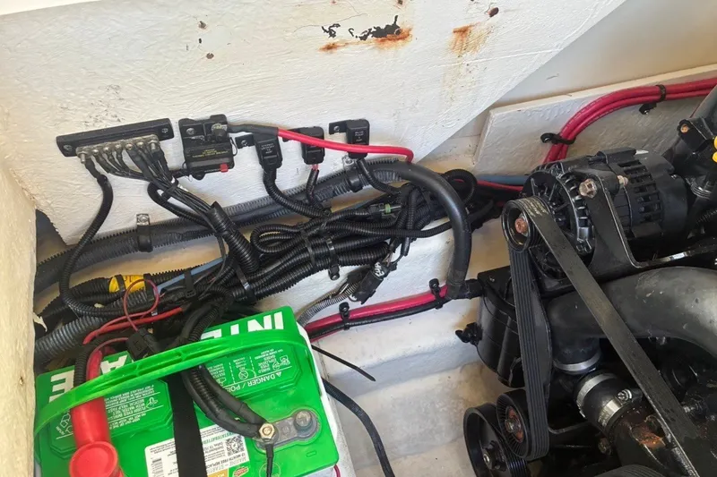 Slide: The Image of Engine compartment of a 2014 Sea Ray 240 Sundeck with visible battery and wiring. - 57