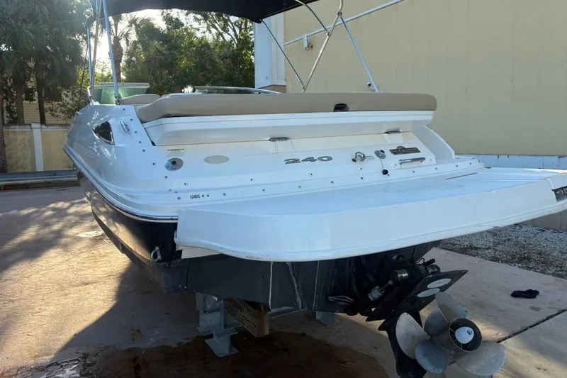 Slide: The Image of 2014 Sea Ray 240 Sundeck boat with outboard motor, docked outdoors. - 8