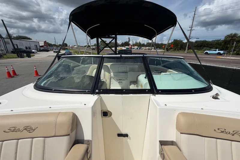 Slide: The Image of 2014 Sea Ray 240 Sundeck boat with beige seating and black canopy. - 65