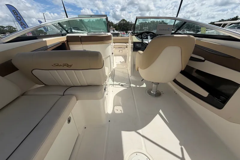 Slide: The Image of 2014 Sea Ray 240 Sundeck interior with beige seating and steering console. - 21