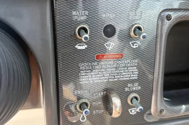 Slide: The Image of Control panel of a 2014 Sea Ray 240 Sundeck with warning labels and switches. - 36
