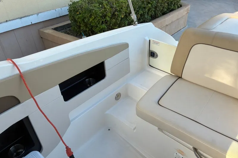 Slide: The Image of Interior seating of a 2014 Sea Ray 240 Sundeck boat with beige upholstery. - 47