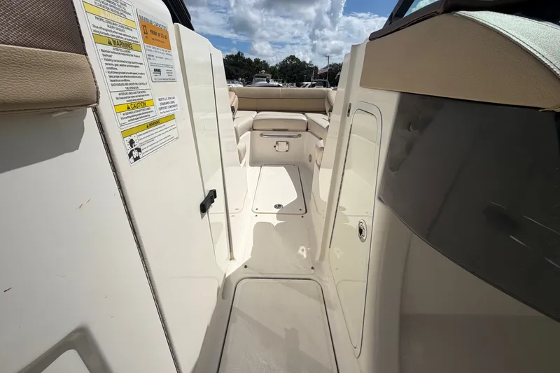 Slide: The Image of 2014 Sea Ray 240 Sundeck interior with seating and safety labels. - 43