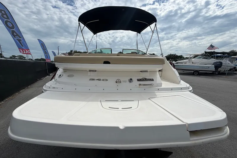 Slide: The Image of 2014 Sea Ray 240 Sundeck boat with canopy, displayed at a sales event. - 4