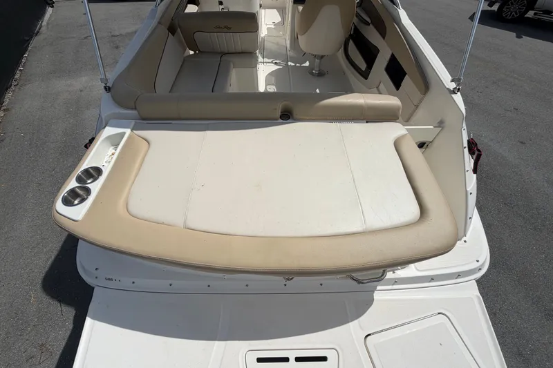Slide: The Image of 2014 Sea Ray 240 Sundeck boat interior with beige seating and cup holders. - 13