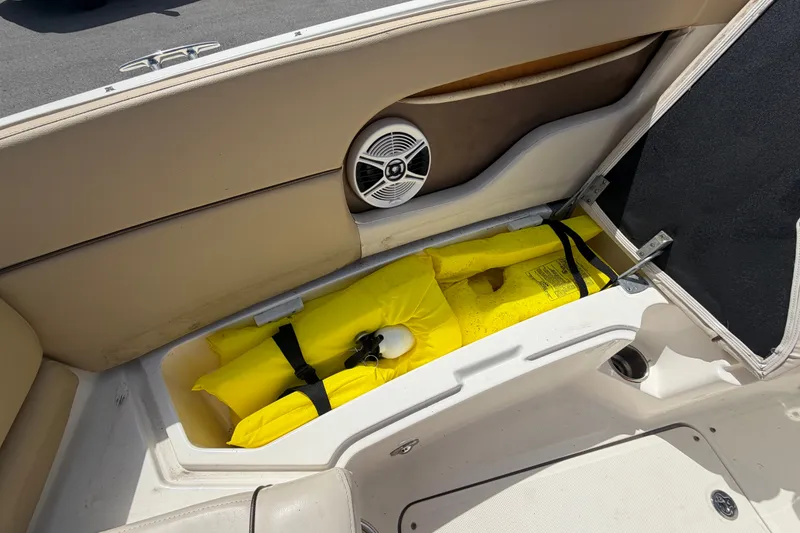 Slide: The Image of Storage compartment with life jacket in a 2014 Sea Ray 240 Sundeck boat. - 56