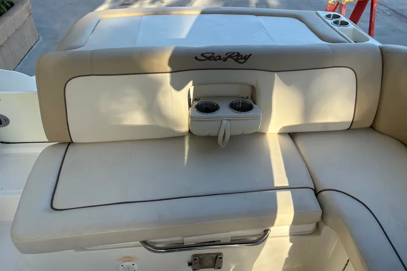 Slide: The Image of 2014 Sea Ray 240 Sundeck boat seating area with cup holders, beige upholstery. - 39