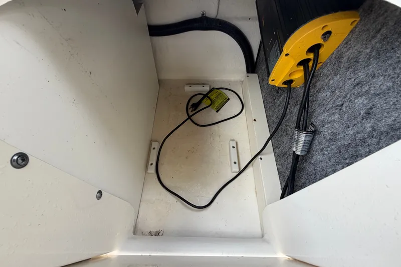 Slide: The Image of Storage compartment of a 2014 Sea Ray 240 Sundeck boat with wiring and equipment. - 75