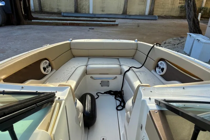Slide: The Image of 2014 Sea Ray 240 Sundeck interior with beige seating and marine speakers. - 16