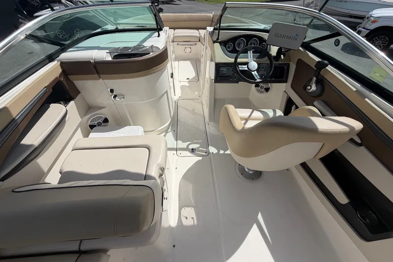 Slide: The Image of 2014 Sea Ray 240 Sundeck interior with Garmin navigation, beige seating, and modern dashboard. - 22