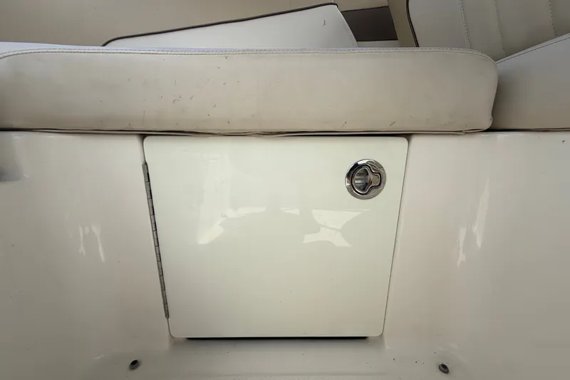 Slide: The Image of 2014 Sea Ray 240 Sundeck storage compartment with cushioned seating above. - 72