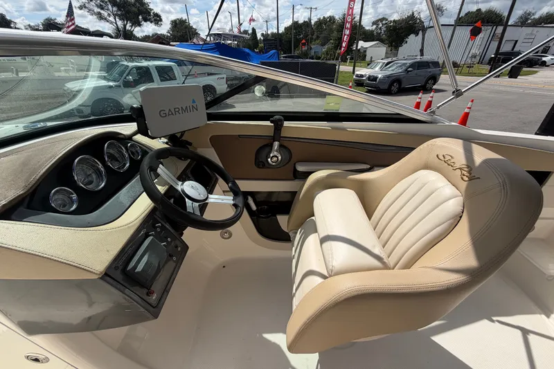 Slide: The Image of 2014 Sea Ray 240 Sundeck cockpit with Garmin navigation and beige captain's chair. - 31
