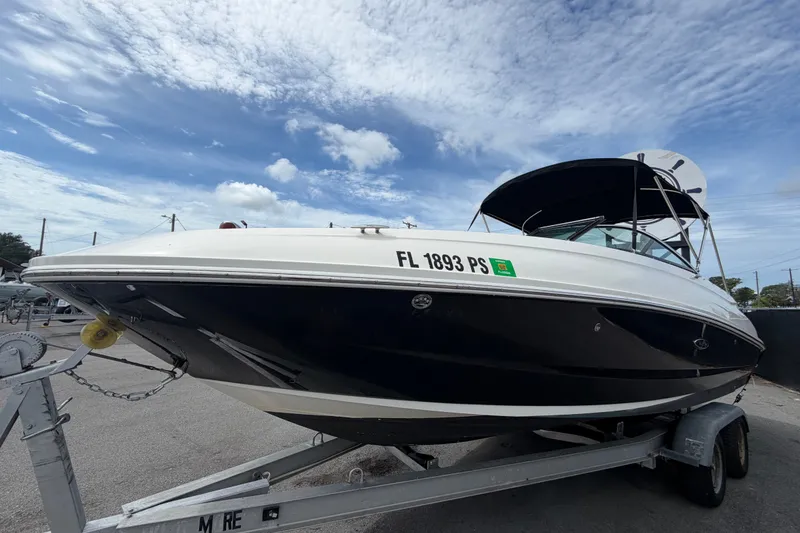 Slide: The Image of 2014 Sea Ray 240 Sundeck boat on trailer under a partly cloudy sky. - 9