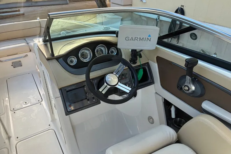 Slide: The Image of 2014 Sea Ray 240 Sundeck cockpit with Garmin navigation system and steering wheel. - 40