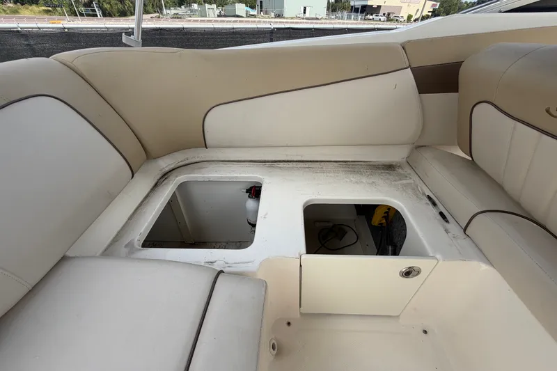 Slide: The Image of 2014 Sea Ray 240 Sundeck interior storage compartments with beige seating. - 74