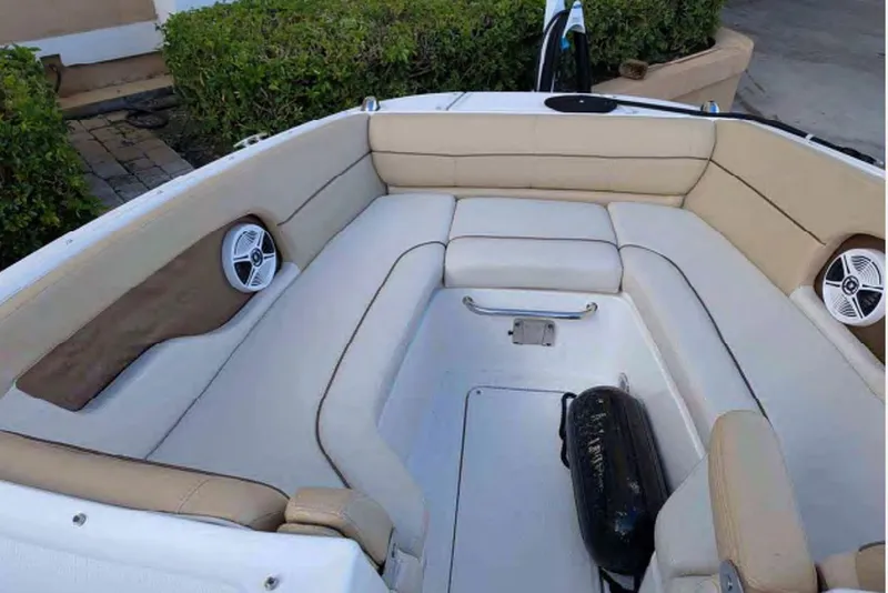 Slide: The Image of Interior view of a 2014 Searay SDX 240 boat with beige seating and speakers. - 5