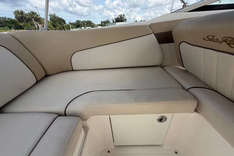 Slide: The Image of 2014 Sea Ray 240 Sundeck interior seating with beige upholstery and storage compartment. - 71