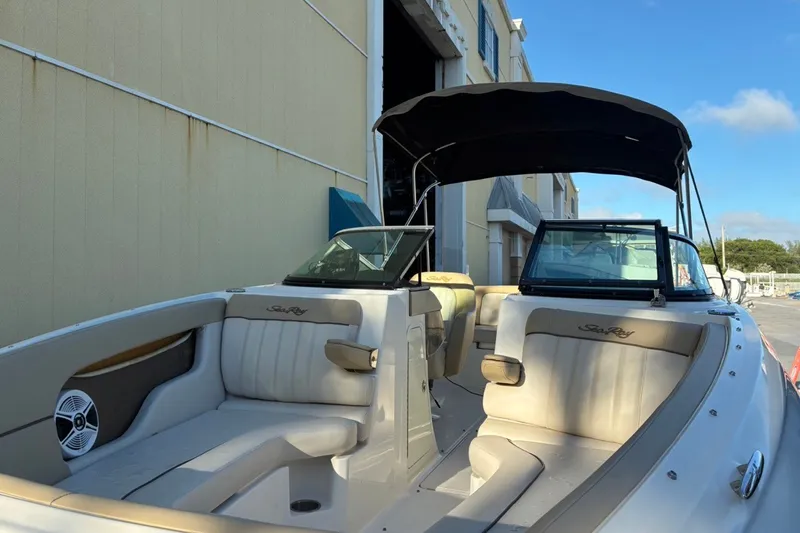 Slide: The Image of 2014 Sea Ray 240 Sundeck boat with spacious seating and canopy, docked outdoors. - 15